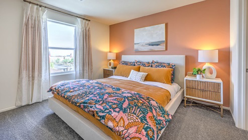 The Bedroom One Suite in our Spectrum Trails 1334 model with carpet flooring, two windows, recessed ceiling lights, and a walk-in closet.