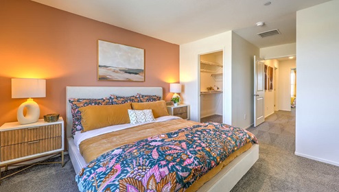 The Bedroom One Suite in our Spectrum Trails 1334 model with carpet flooring, two windows, recessed ceiling lights, and a walk-in closet.