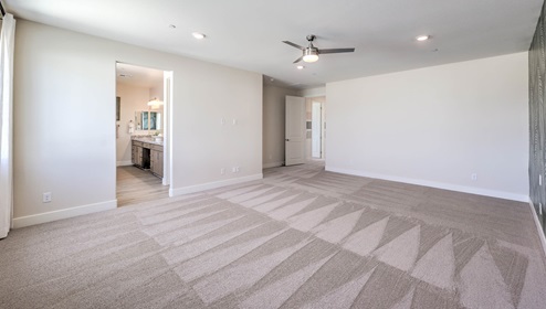 The upstairs loft in our 4425 model with carpet flooring and large windows.