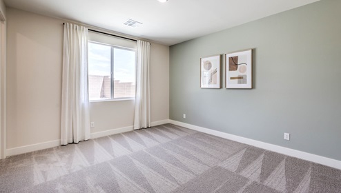 Bedroom Six in our Heartland Summit 4425 Multigen Suite with carpet flooring, a walk-in closet, and a window.