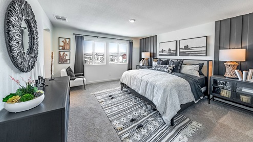 Modern carpeted primary bedroom with large windows