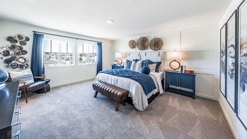 Large primary bedroom with bright windows
