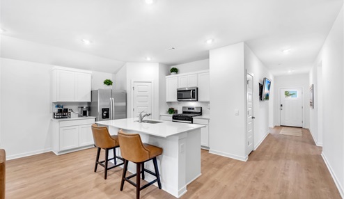 Kitchen peninsula with white cabinets and modern stainless steel appliances.