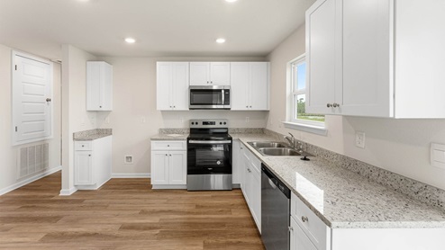 Kitchen with EVP flooring and granite countertops and stainless-steel appliances.