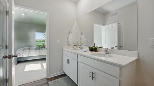 Primary bathroom with double sink and glass door shower