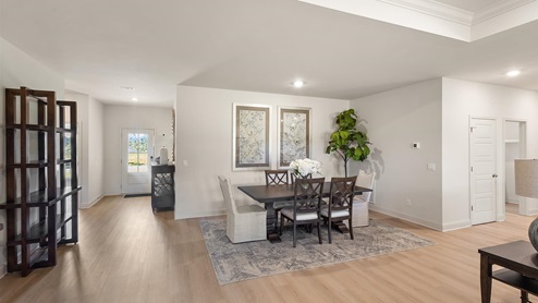 Dining area with hardwood floors and recessed lighting.