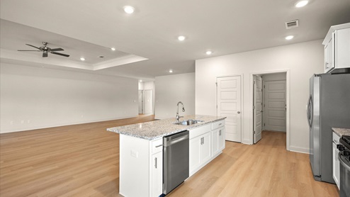 Spacious kitchen with granite countertops, island, and stainless-steel appliances.