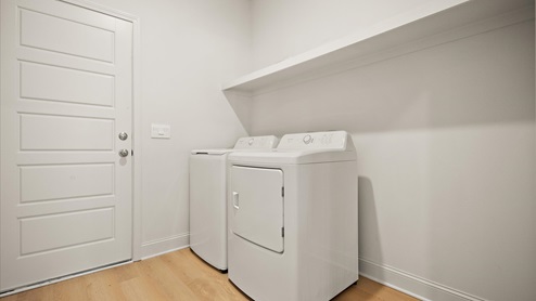 Laundry room with wooden shelving