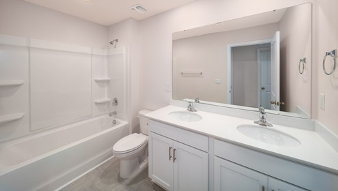 Bathroom wit bathtub, white cabinets and counter