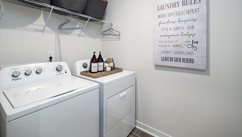 Laundry room with built in cabinets above machines