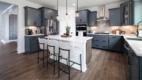 Kitchen and island with wood floors, grey cabinets, quartz counters, and stainless steel appliances
