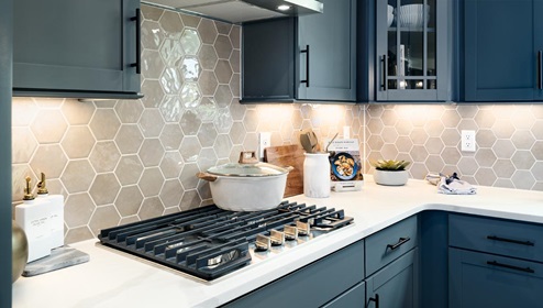 Kitchen and island with wood floors, grey cabinets, quartz counters, and stainless steel appliances