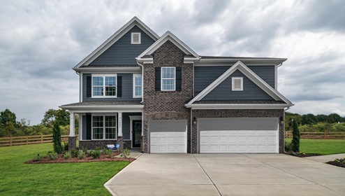 model front exterior with siding, stone, and three car garage