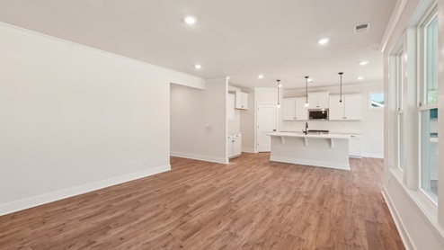 Living room with large windows behind kitchen