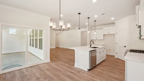 kitchen and island with hanging lights, white cabinets, and stainless steel appliances