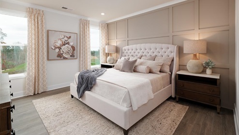 Primary bedroom with hardwood flooring and two large windows