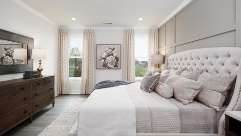 Primary bedroom with carpet and two large windows