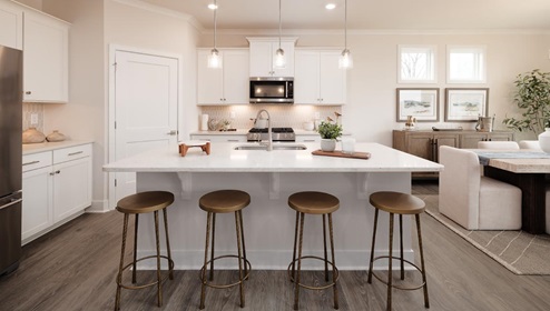 Kitchen and island with white cabinets, Quartz countertops, tile backsplash, and stainless steel appliances