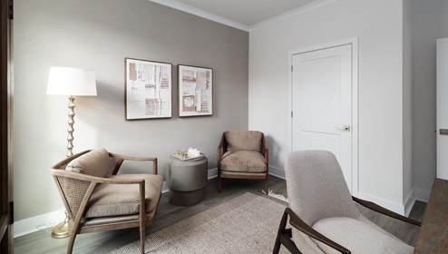 Secondary bedroom with hardwood flooring and large window being used as an office