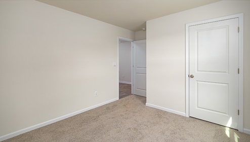 Carpeted bedroom, view of entrance door
