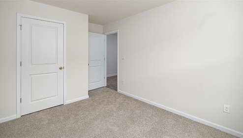 Carpeted bedroom, view of entrance door