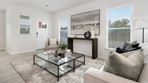 Open concept living room with vinyl flooring and large windows