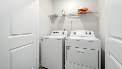 Laundry room with hanging storage racks.