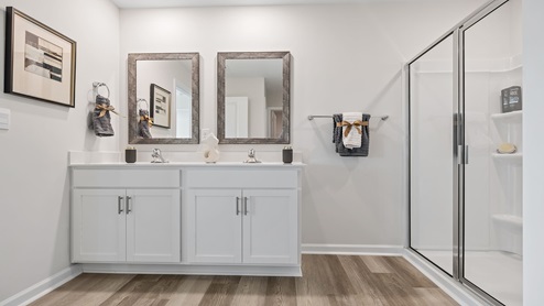 Bathroom with double vanity sink and shower.