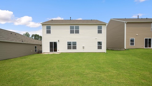 Back exterior of home with large backyard.