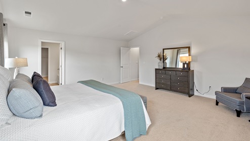 primary bedroom with carpet and windows.