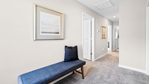Loft area with carpet and view of rooms.