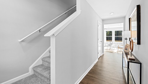 Hallway into home with view of stairs.