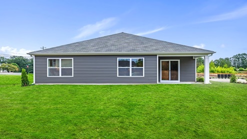 Back exterior of home with large backyard.