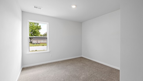Bedroom with carpet and window.