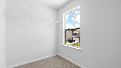 Closet with carpet and window.