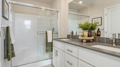 Misty Meadows Primary bathroom with double vanity, walk in shower, toilet, quartz countertops