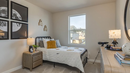 Misty Meadows bedroom with end table, dresser, lights, paintings, and window