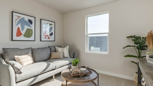 Misty Meadows bedroom den with couch, coffee table, plant, window, and paintings
