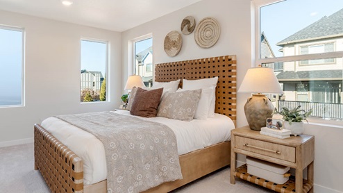 Scholls Meadow Primary Bedroom white sheets and brown bed frame, blankets, pillows, nightstands with lamps, decorative hanging pieces, windows, and carpet