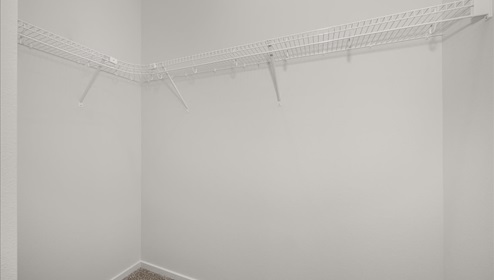 A walk in closet with wire shelving.
