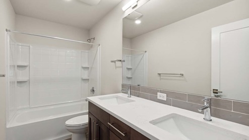 Upper floor full bath with tub-shower combo and dual-sink vanity with quartz countertop and tile backsplash