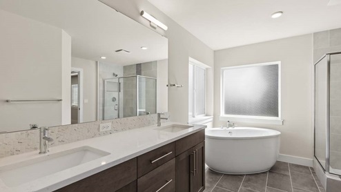 View of dual vanity with undermount sinks, quartz countertop and accent tile backsplash