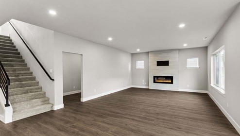 Alternate view of Baker floor plan dining nook and living room with stairwell featuring open rail near entry mud room and interior garage entry door