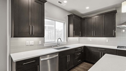 Baker floor plan kitchen close up showcasing quartz countertops, and a large undermount sink with bright window above