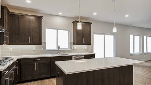 Kitchen includes expansive quartz countertops and tile backsplash