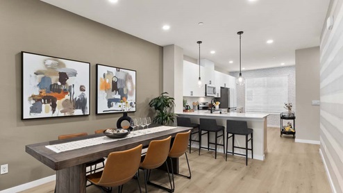 dining area with modern dining table kitchen peninsula with barstools and pendant lighting