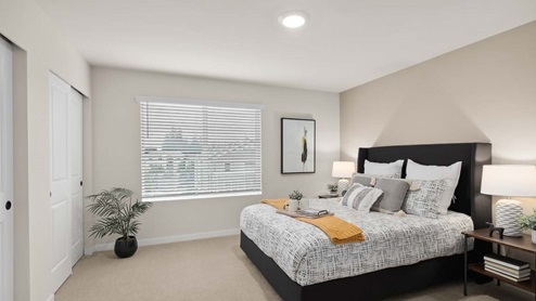 primary bedroom with queen bed, night stand and closet