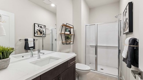 Main floor bathroom with shower and chrome fixtures and tile backsplash