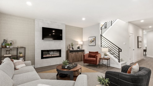 spacious living room looking towards stairway to upper level and to entry