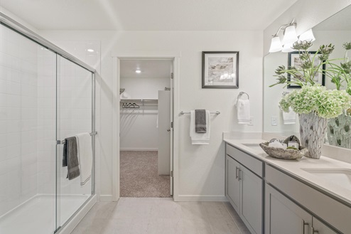 main bathroom with a shower and grey cabinets
